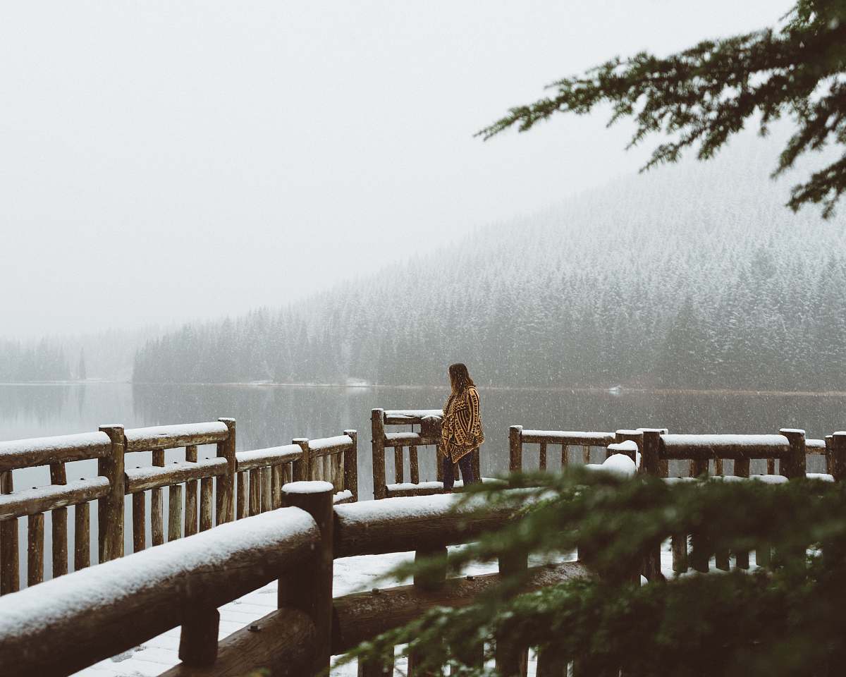 fence woman walking towards brown wooden bridge railing